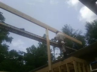 Carpenter setting a ridge beam over a new addition frame — Ice Dam Removal by Roofing Brothers in Mendota