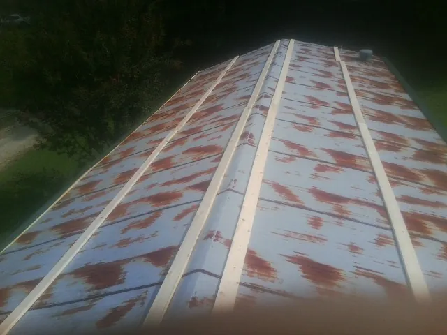 Rusted metal roof panels with new wood purlins before replacement — Storm Damage Roof Repair in Mendota by Roofing Brothers