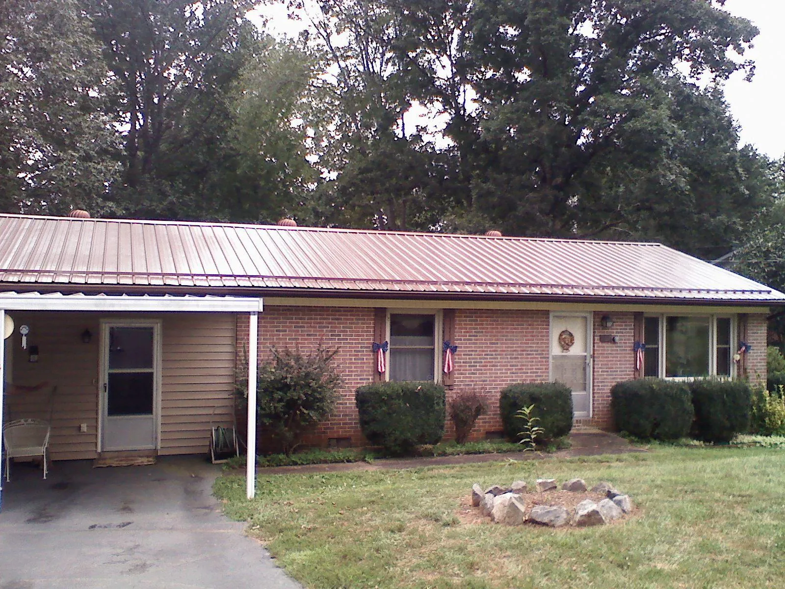 Bronze metal roof and carport on a brick ranch home — Roof Repair work by our crew in Mendota